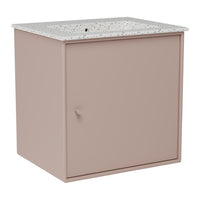 Blush pink vanity cabinet with a speckled white countertop. Modern minimalist design.
