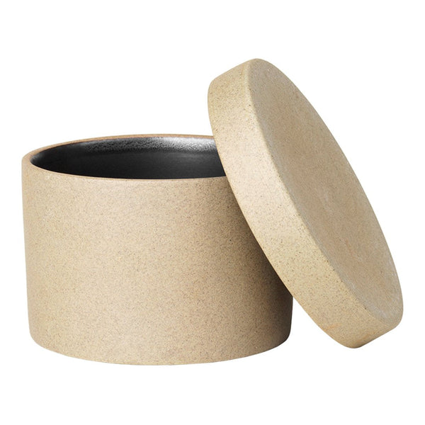 Round beige storage container with a smooth exterior and black interior, featuring a minimalistic design.