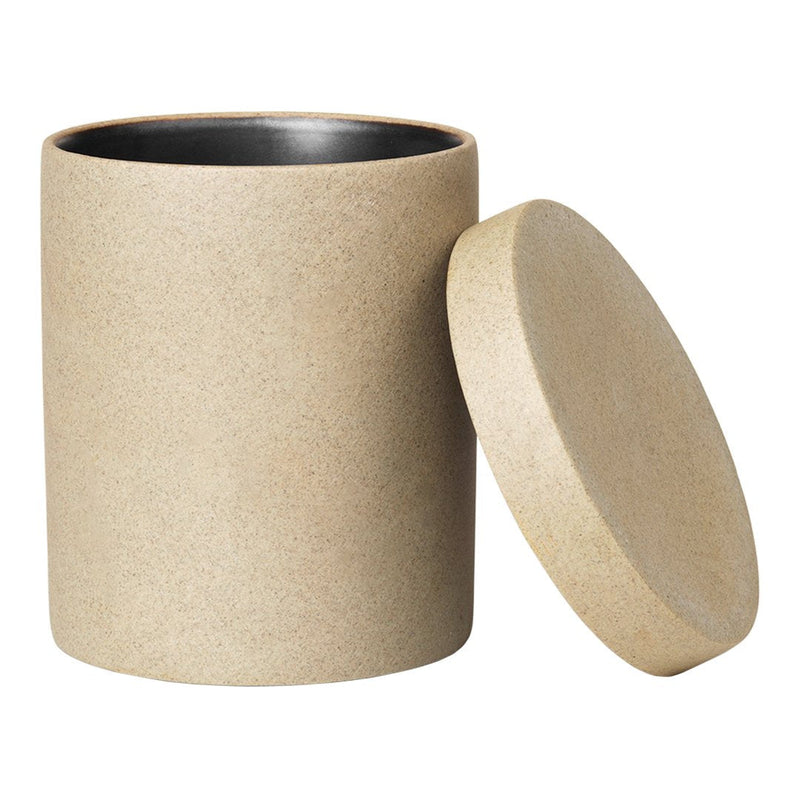 Neutral beige cylindrical container with a smooth, matte finish and contrasting black interior. Elegant and modern design.