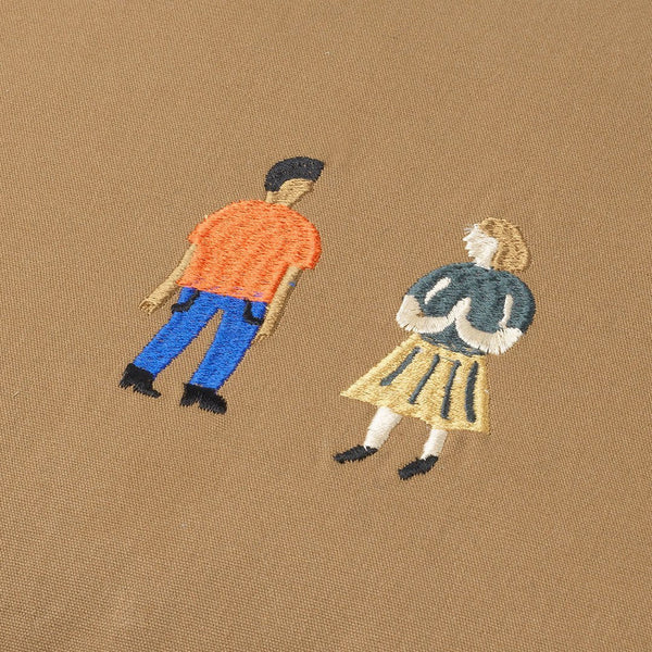 Embroidered design featuring a brown background, with colorful figures in orange, blue, yellow, and green.