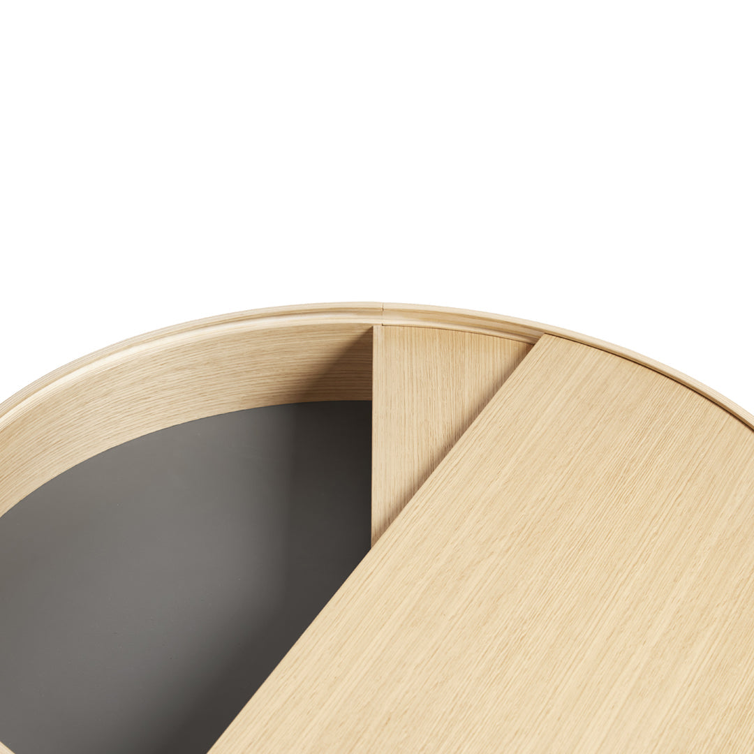 Light oak wood table with a smooth gray circular panel, featuring a minimalist design and subtle wood grain patterns.