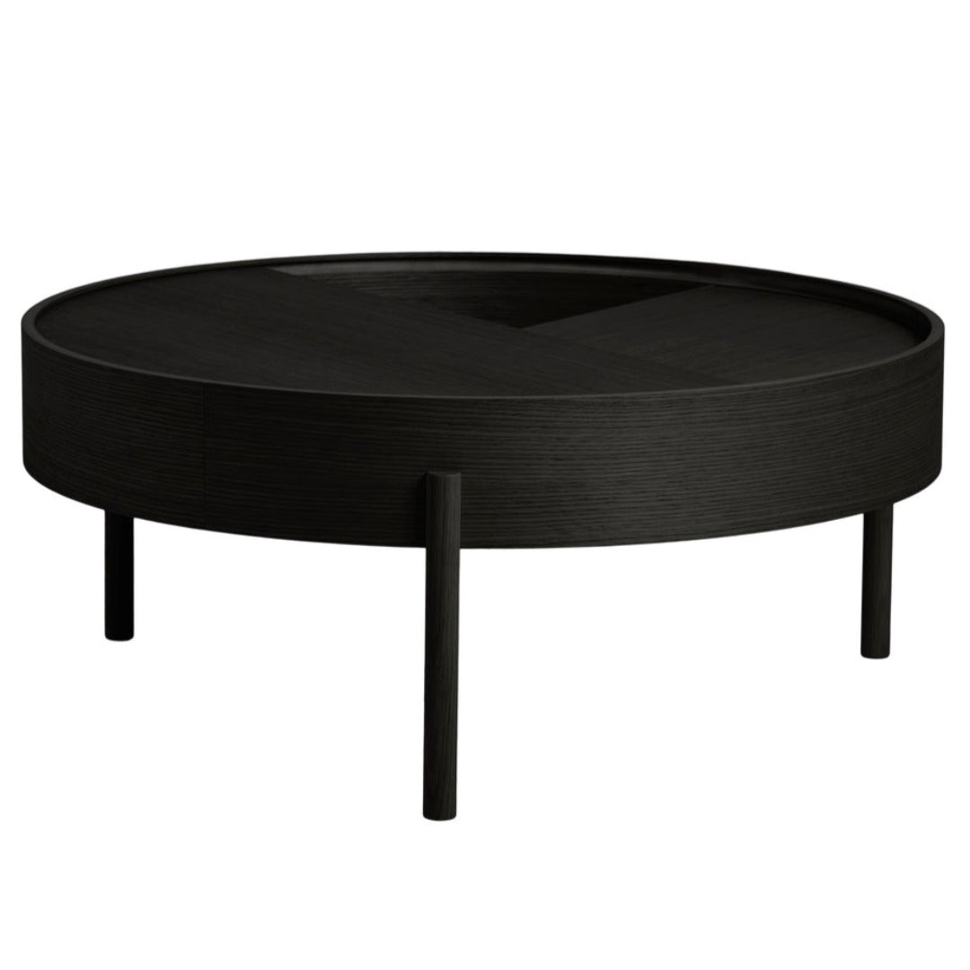 Black round coffee table with a textured finish and minimalist design, featuring three slender legs.