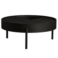 Black round coffee table with a textured finish and minimalist design, featuring three slender legs.