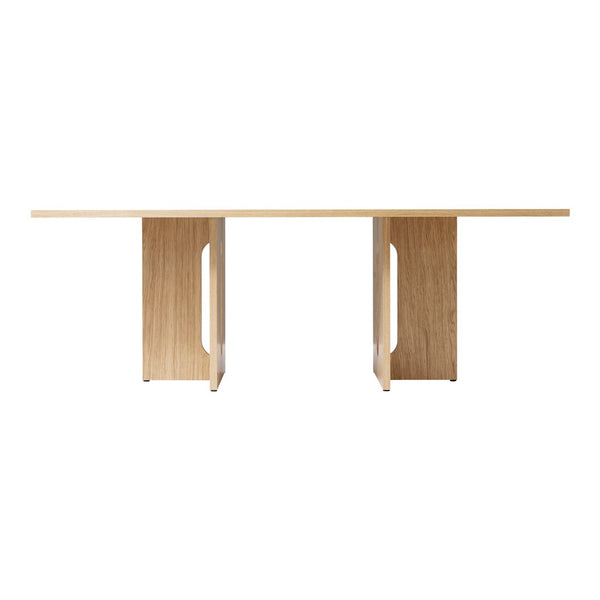 Light oak dining table with a smooth natural finish and sleek geometric patterns in the pedestal design.