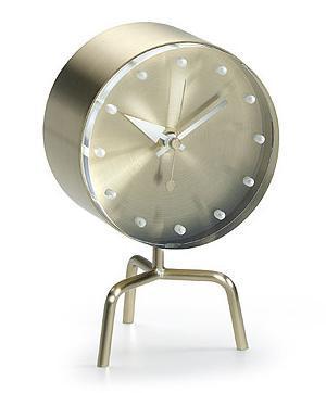 Gold metallic clock with minimalist design and white clock face, featuring simple hour markers and sleek stand.