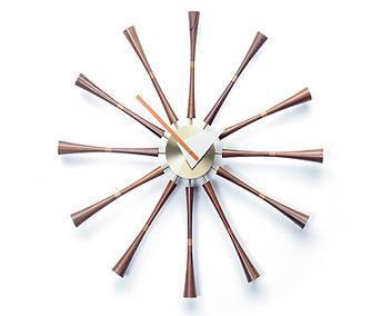 Mid-century modern clock with a brass center, walnut rays, and a minimalist design showcasing a sunburst pattern.