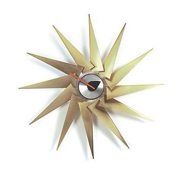 Gold starburst wall clock with sharp, angular spikes and a sleek black and silver center. Ideal for modern decor.