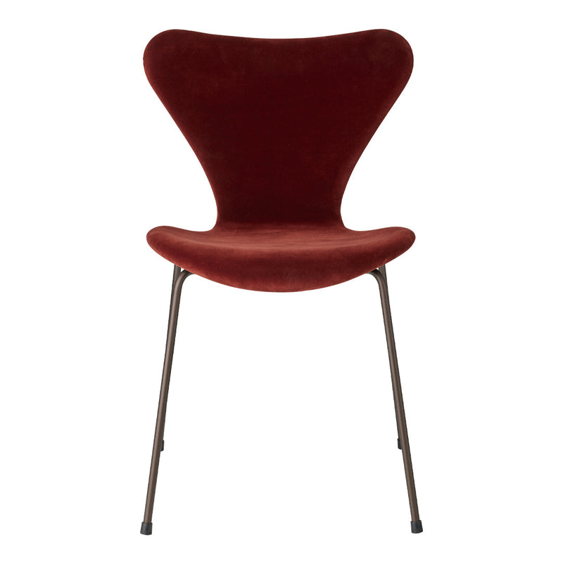 Curved velvet chair in rich burgundy with sleek metal legs, perfect for modern decor.