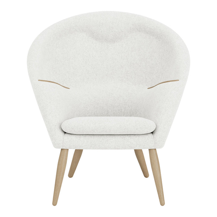 White upholstered chair with subtle texture and light wood legs, featuring soft curves and minimalistic design.