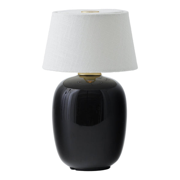 Black ceramic lamp with a textured white shade and gold accent. Perfect for modern home decor styling.