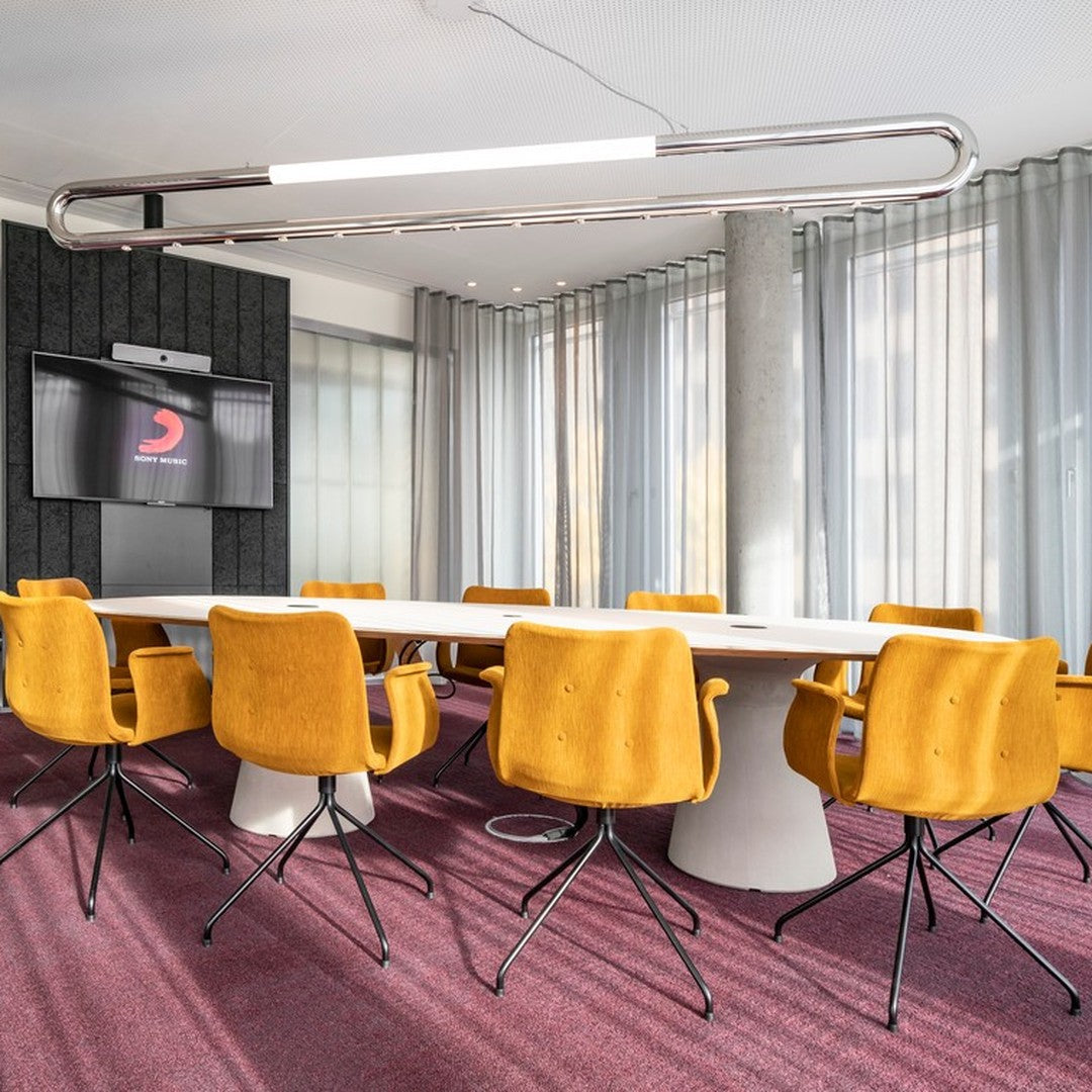Modern conference room with bright yellow chairs and a rich purple carpet, featuring soft textures and clean lines.