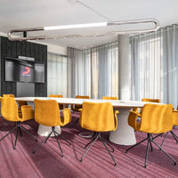 Modern conference room with bright yellow chairs and a rich purple carpet, featuring soft textures and clean lines.