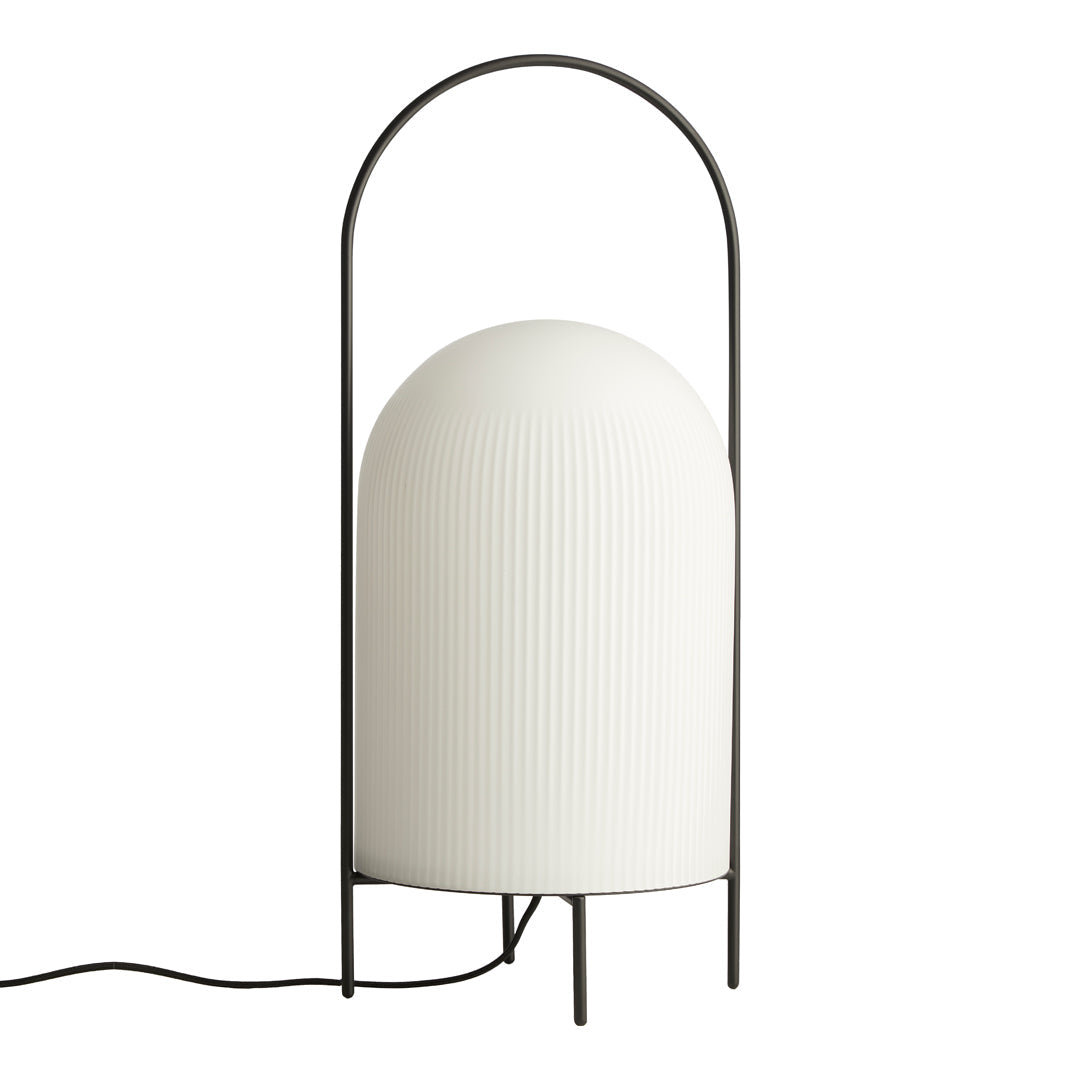 Modern white ribbed lamp with a black metal arch base, adding a sleek and elegant touch to any decor.