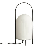 Modern white ribbed lamp with a black metal arch base, adding a sleek and elegant touch to any decor.