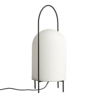 White ribbed lamp with a sleek black metal frame and stylish arched handle, perfect for modern decor.