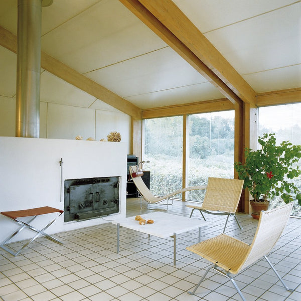 Modern living room featuring light wood beams, neutral tones, and a grid-patterned tile floor. Bright natural light highlights colors.