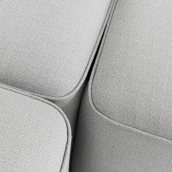 Soft light gray textured fabric with seamless curves and subtle detailing, ideal for modern furniture design.