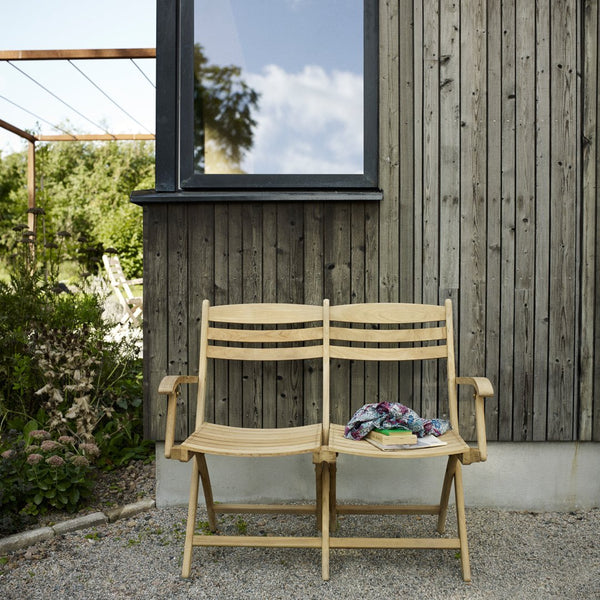 "Natural wood finish benches with a simple design, featuring colorful patterned fabric draped across the seat."