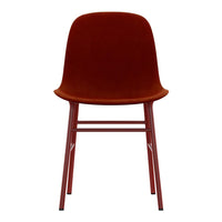Rust velvet chair with smooth curves and matching red legs, perfect for stylish home decor.