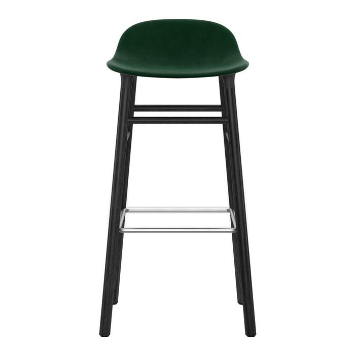Green velvet bar stool with a sleek black frame and chrome footrest, featuring a smooth, modern design.