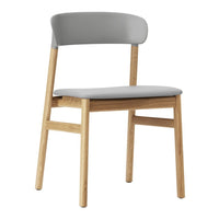 Gray upholstered chair with light wood frame, featuring a minimalist design and smooth, modern lines.