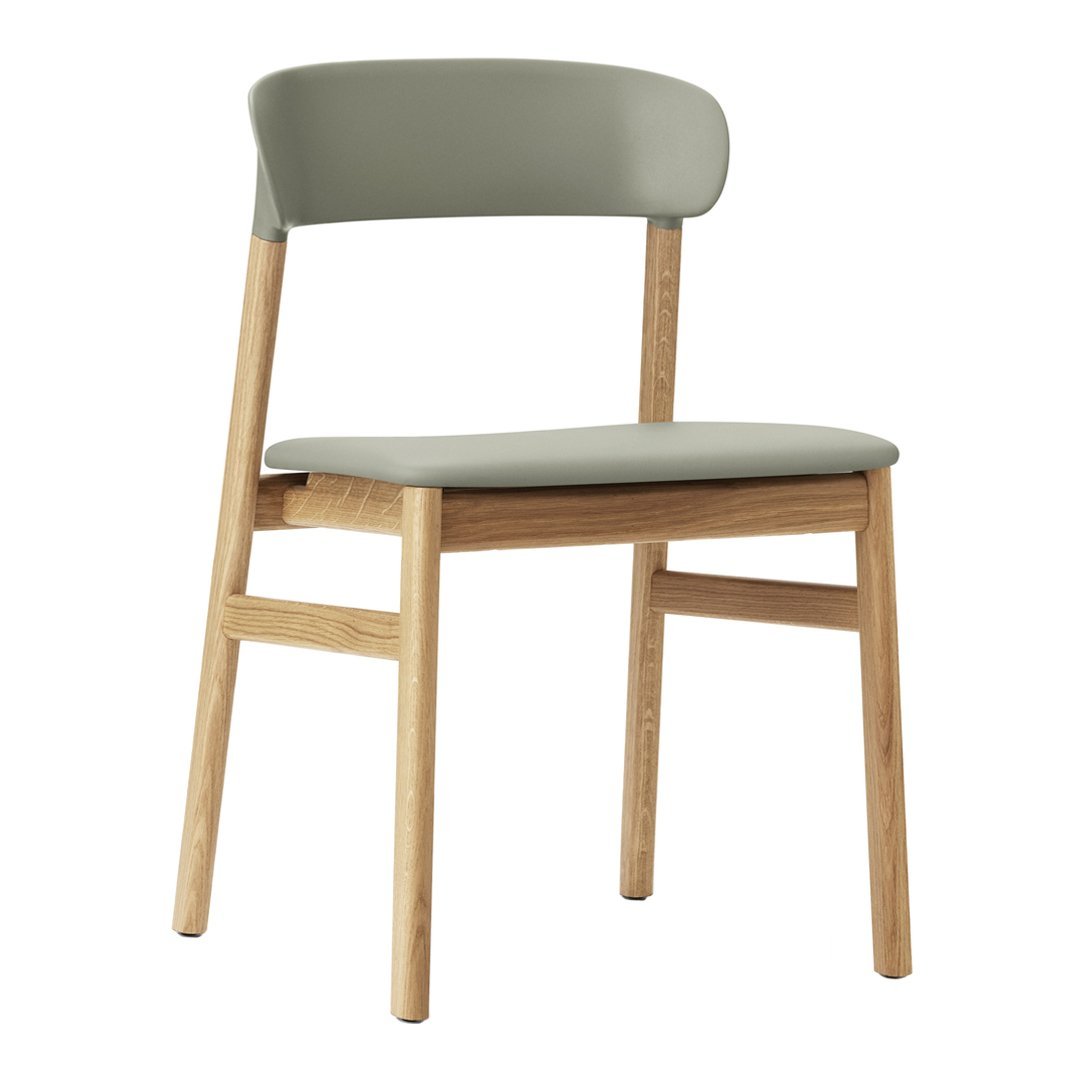 Stylish chair featuring a soft olive green seat and backrest with natural wood legs and a minimalist design.