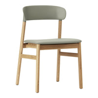 Stylish chair featuring a soft olive green seat and backrest with natural wood legs and a minimalist design.