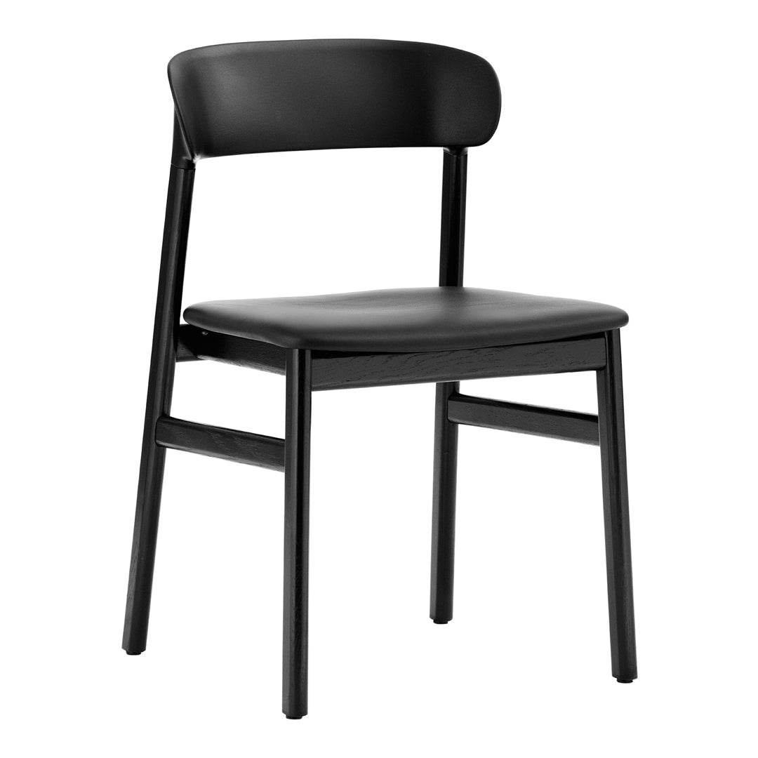"Solid black dining chair with a minimalist design and sleek matte finish."