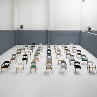 Colorful chairs in distinct patterns: green, black, gray, and white, arranged in a modern, minimalist setting.
