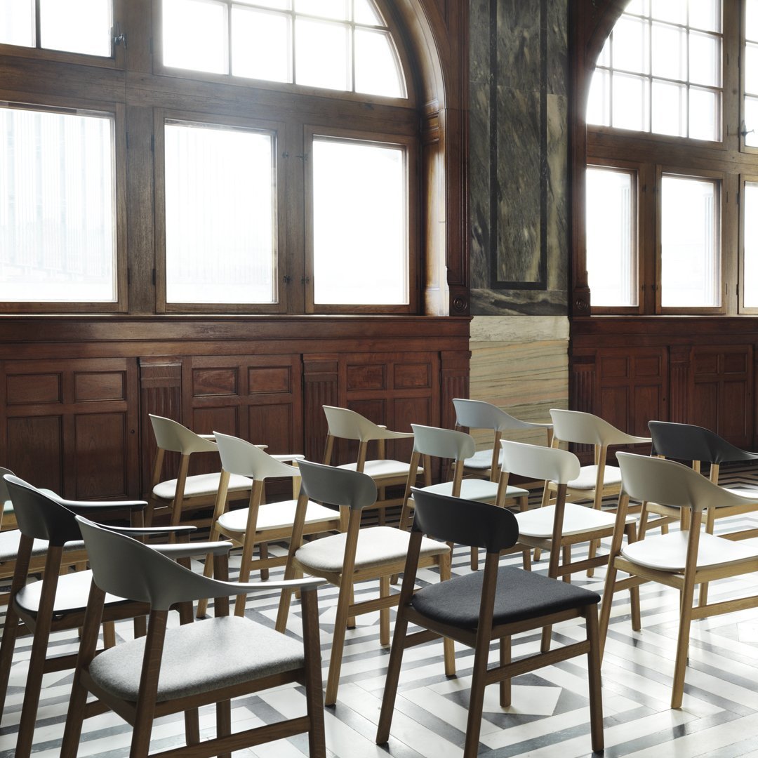 "Elegant wooden chairs in neutral tones of gray, black, and natural wood, arranged in a stylish indoor setting."