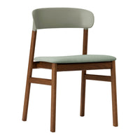 Light green upholstered chair with a natural wood frame, featuring a sleek, modern design and minimalist style.