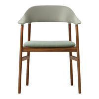 Light green chair with a rounded back and wooden legs, showcasing a minimalist design. Soft fabric seat cushion.