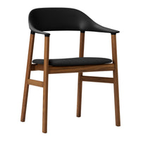 Black curved chair with a wooden frame, featuring a sleek and modern design, perfect for stylish interiors.