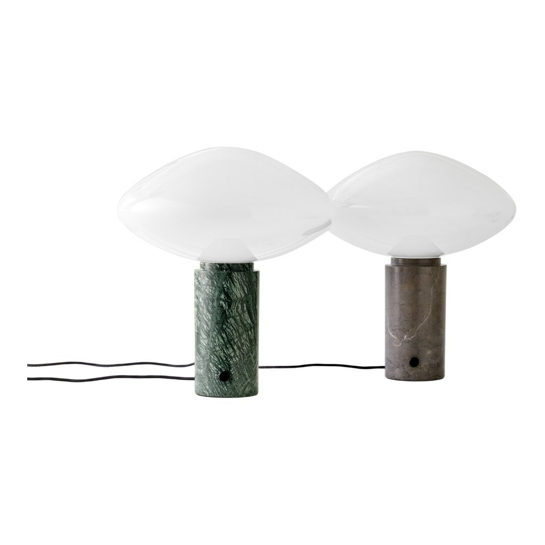 Green and gray marble lamp bases with sleek white glass globes, showcasing modern and elegant design elements.