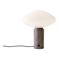 White glass lamp shade on a gray marble base, with a sleek, modern design and smooth finish.