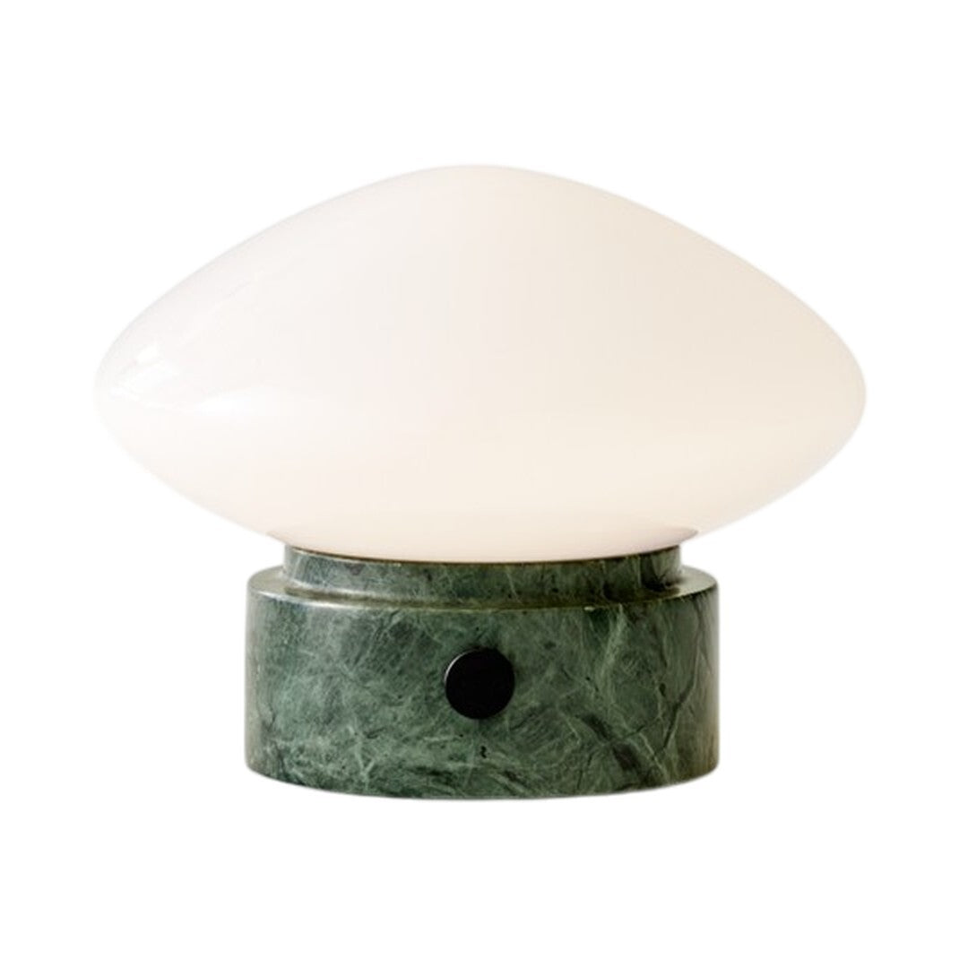 White glass lamp with a smooth, oval shape resting on a green marble base with intricate patterns.