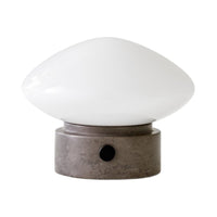 White glass lamp shade with a smooth, curved design atop a textured gray base and a simple black switch.