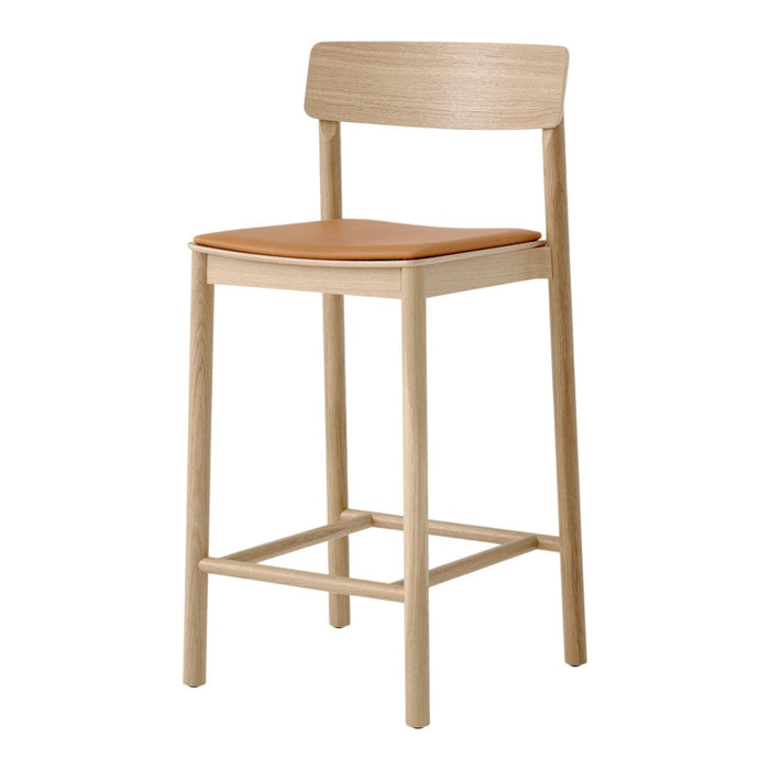 Light wood bar stool with a natural finish and a tan leather seat, minimalist design and sleek lines.