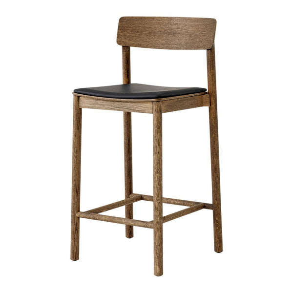 Wooden bar stool with a natural finish and black cushioned seat, showcasing a sleek, modern design.