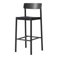 Black bar stool with a sleek design and a matte finish, featuring a simple, modern pattern. Perfect for minimalist decor.