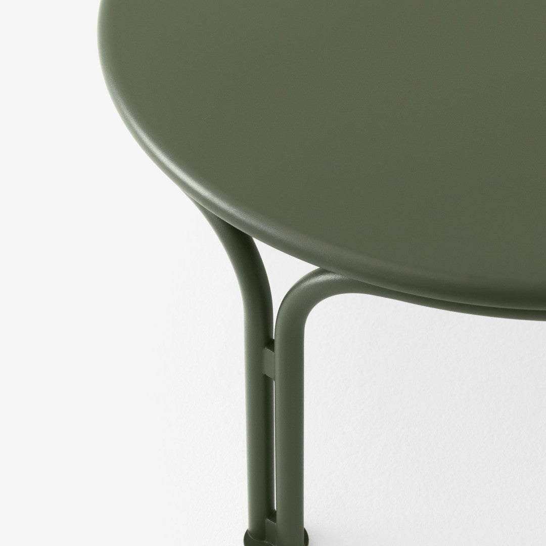 Green round table with a smooth finish and sleek metal legs, featuring a minimalist design.