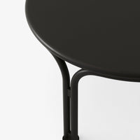 Round black table with sleek matte finish and minimalist black metal legs. Stylish and contemporary design.