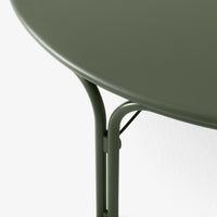 Round green table with a matte finish and sleek metal legs, featuring a minimalist design and subtle curves.