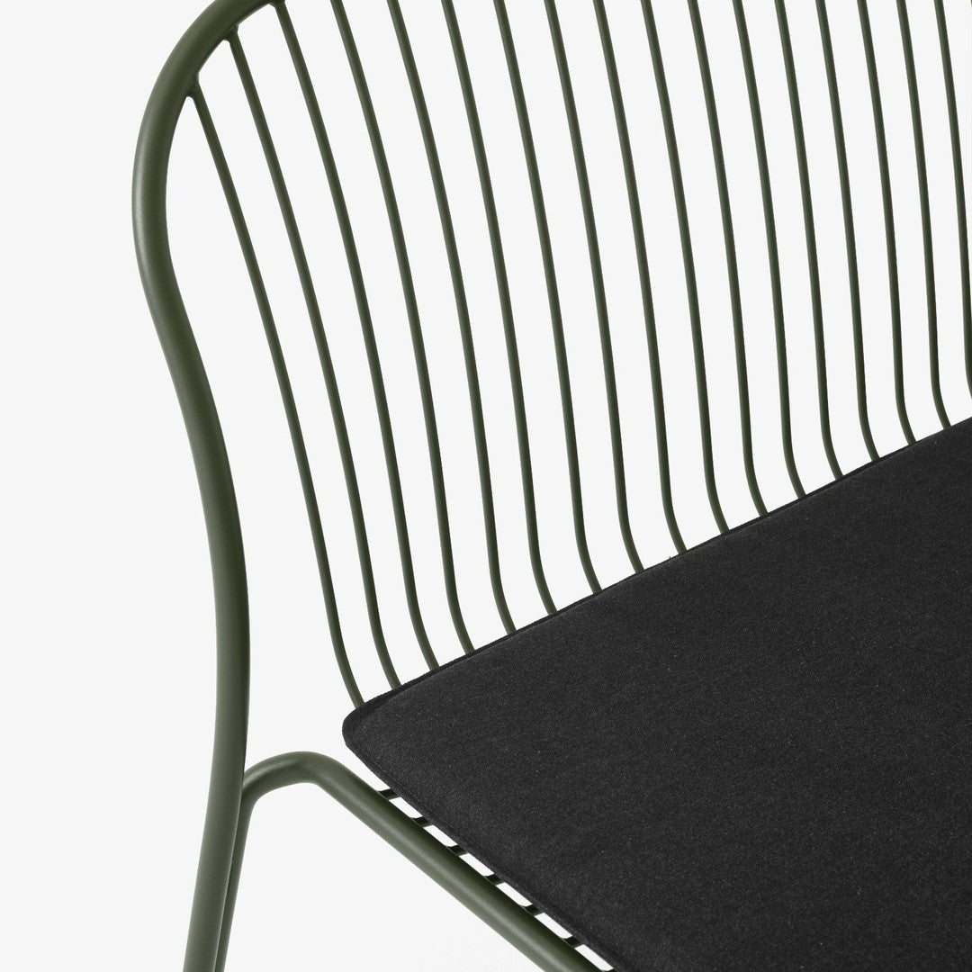 Green metal chair with a sleek, striped backrest and a solid black cushion. Modern design adds a stylish touch.