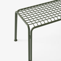 Green metallic bench with a geometric grid pattern and simple, minimalist design.