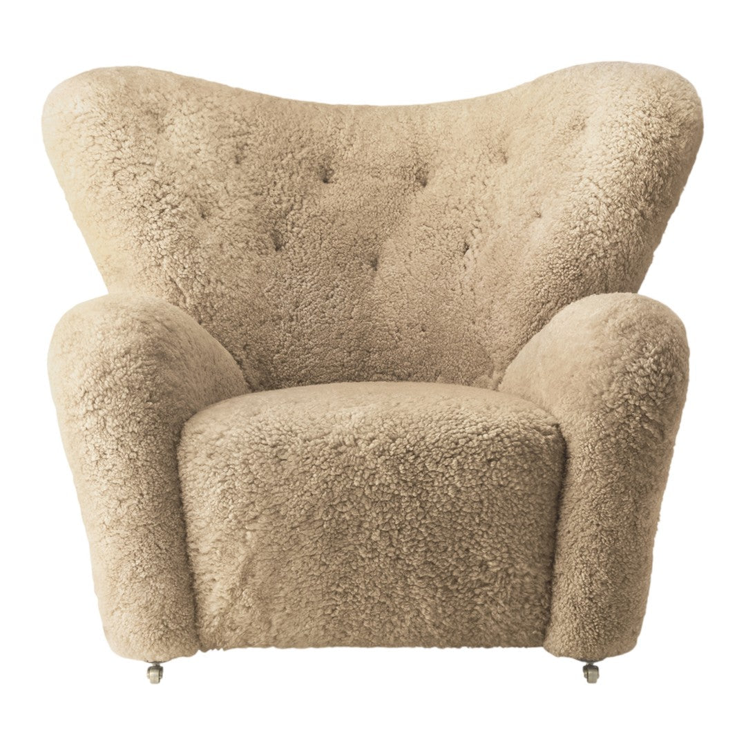 Beige tufted chair with a plush texture and curved silhouette, adding cozy sophistication to any space.
