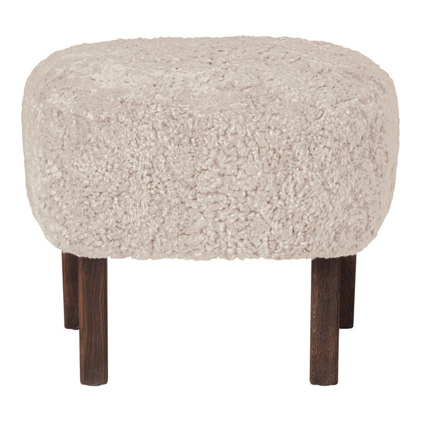 Textured beige ottoman with a fluffy surface and dark wooden legs, perfect for cozy decor.