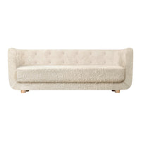 Cream-colored, tufted sofa with a soft, textured fabric and minimalistic design on wooden legs.