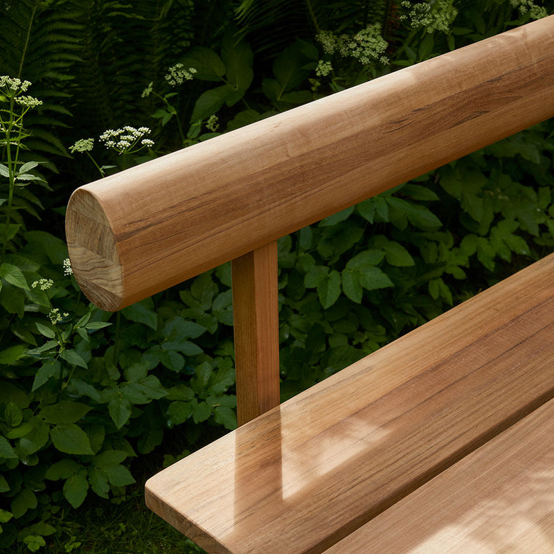 Close-up of natural wood grain and warm honey tones on a stylish outdoor bench. Perfect for garden settings.