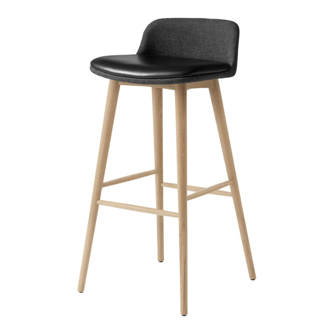 Black upholstered bar stool with natural wood legs, featuring a sleek, minimalist design.